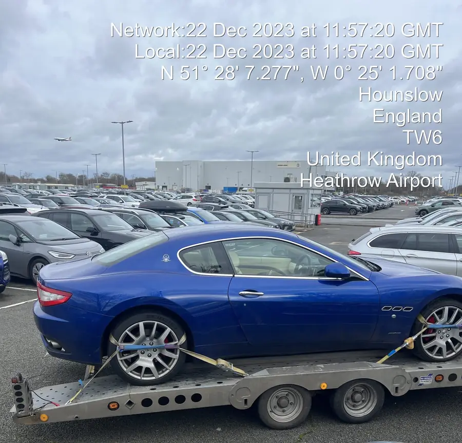 Collection photo of a blue Maserati on the ADR trailer at Heathrow Airport, stamped with date, time and GPS position